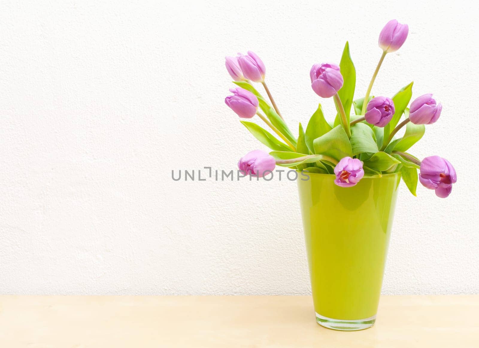 Pink Tulips Bouquet in Green Glass Vase on Wooden Table