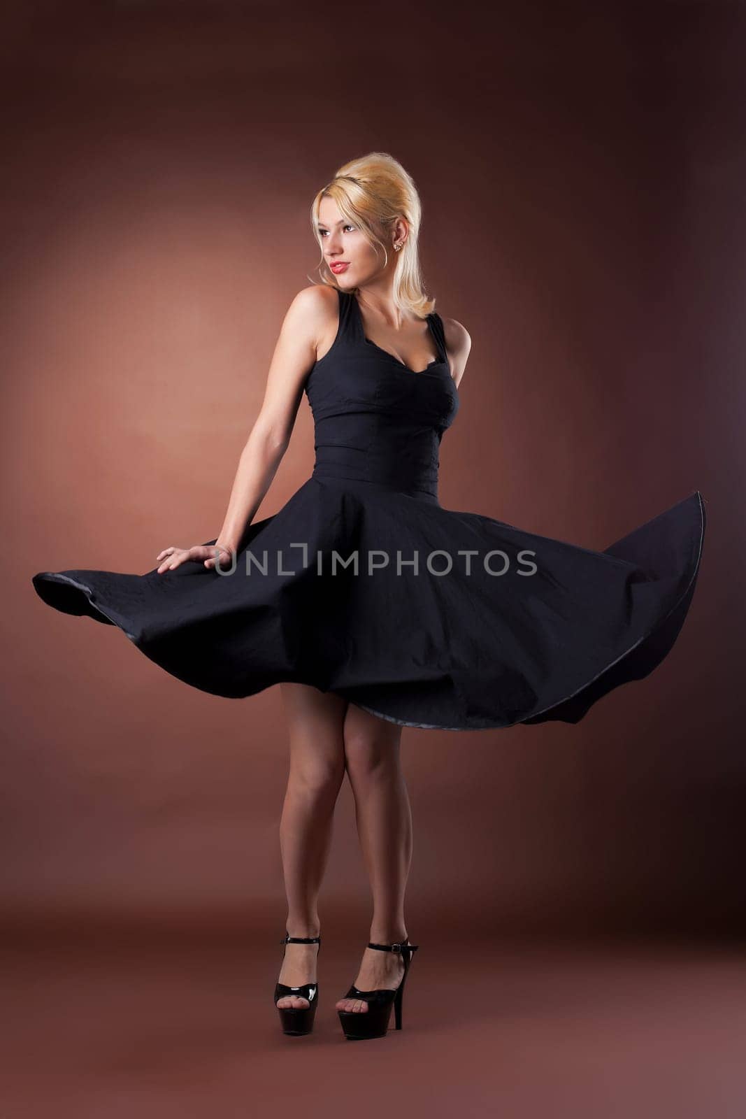 Cute woman in black pinup style dance on dark background