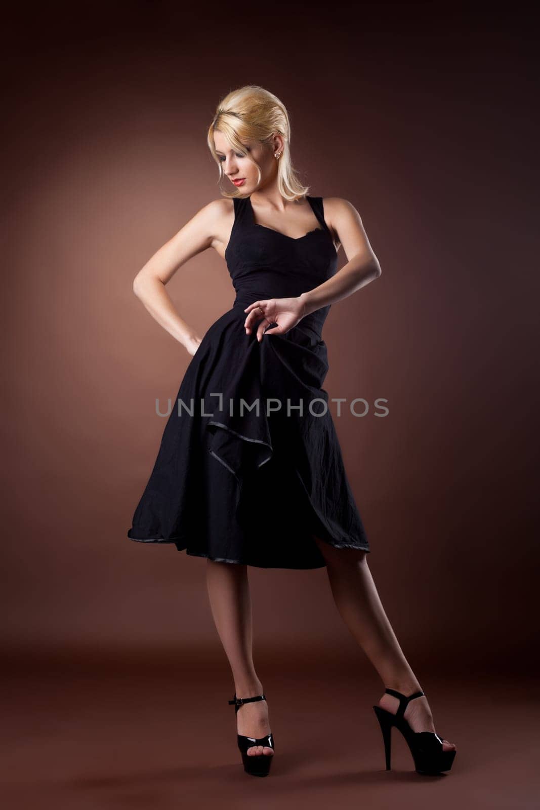 Cute woman in black pinup style dance on dark background