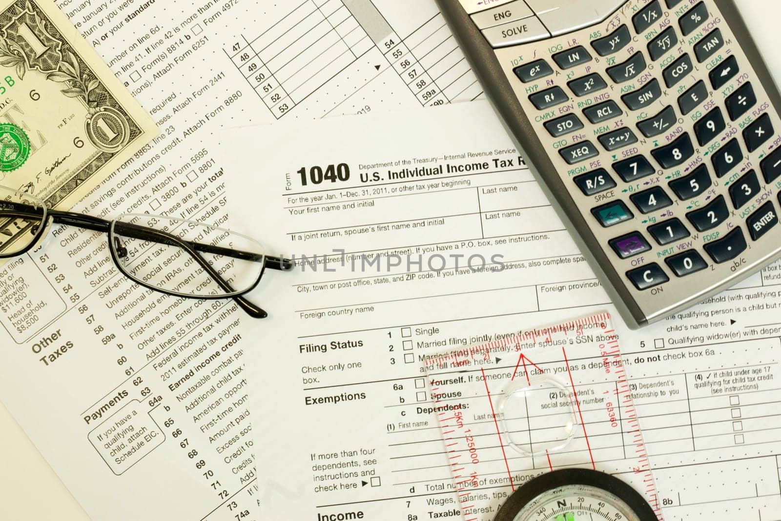 1040 individual tax form with calculator, glasses, compass and money