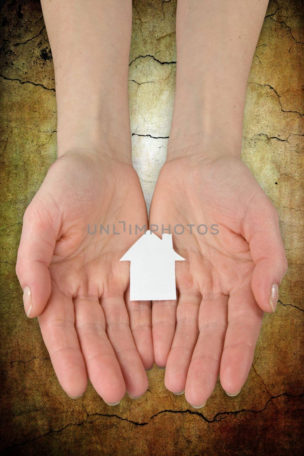 Real estate concept. hands holding a paper house icon