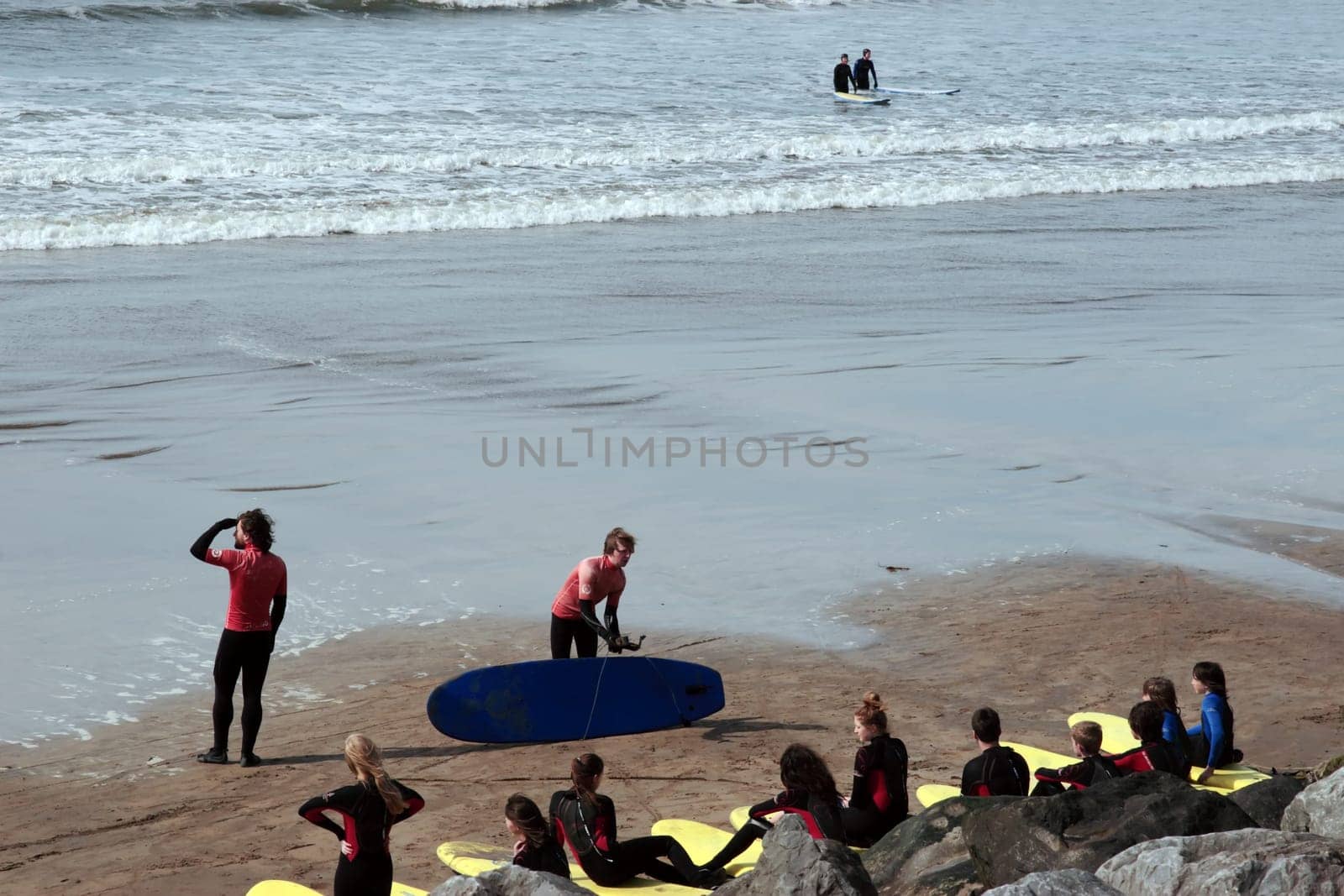 surfing school students being taught on the beach in lahinch county clare ireland on a beautiful day