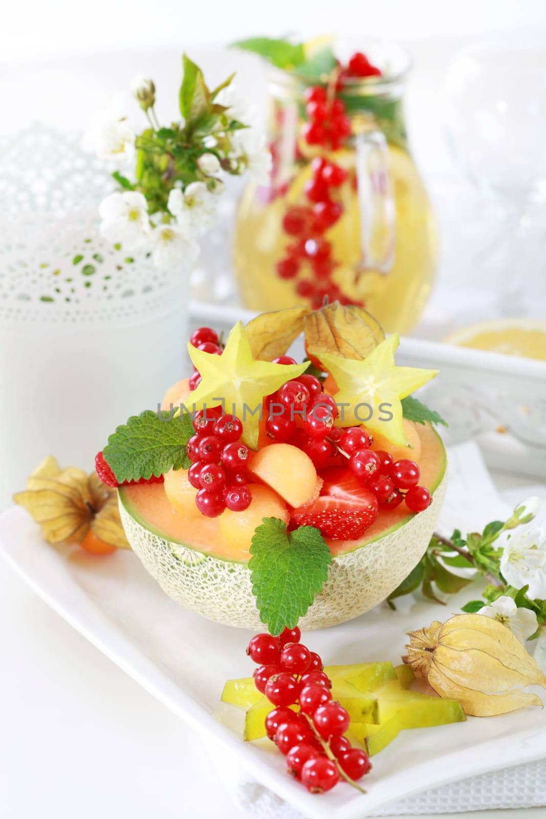 Delicious fresh fruits served in melon bowl as dessert with lemonade