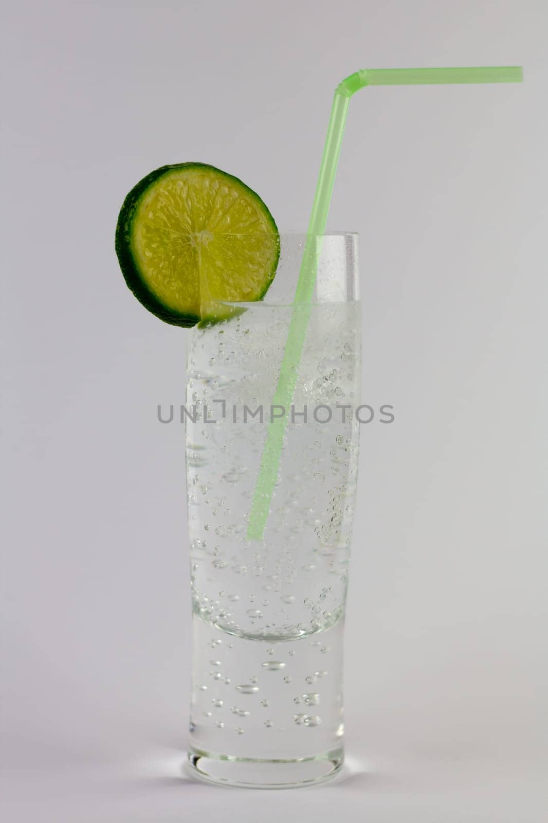 A glass of gin and tonic with ice and lime