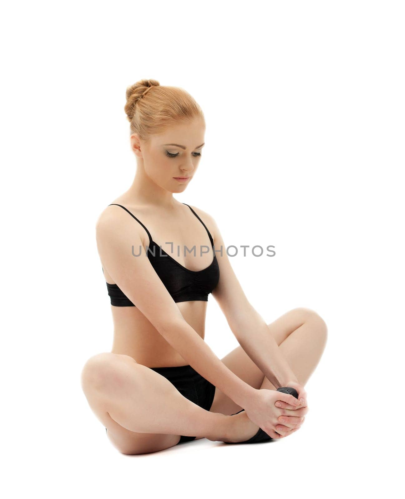 Cute blond girl sit in yoga lotos asana pose on white isolated
