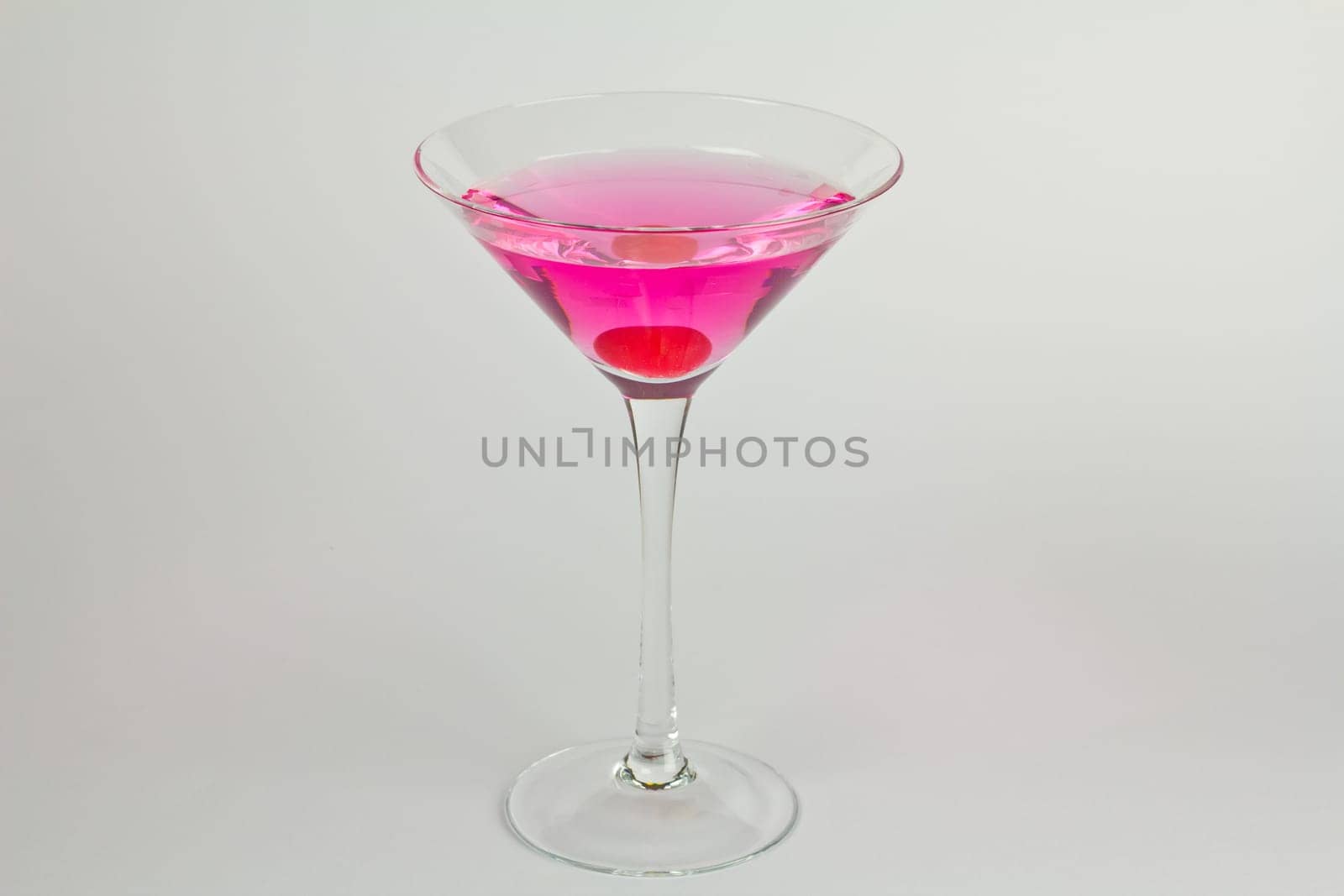 Pink martini cocktail with a cherry garnish