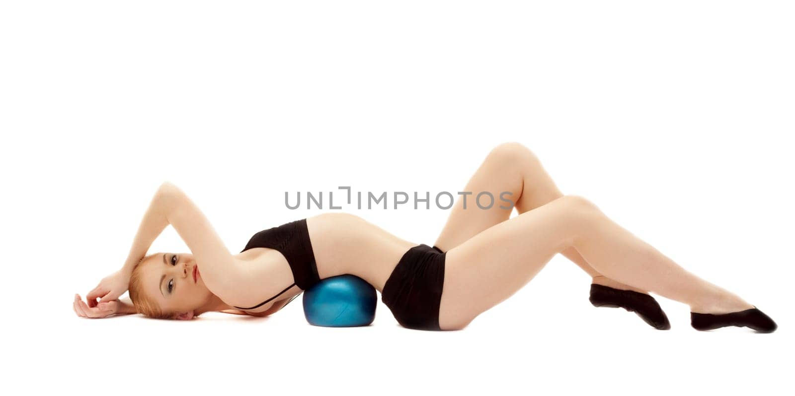 young girl in black training cloth lay on gymnastic ball isolated
