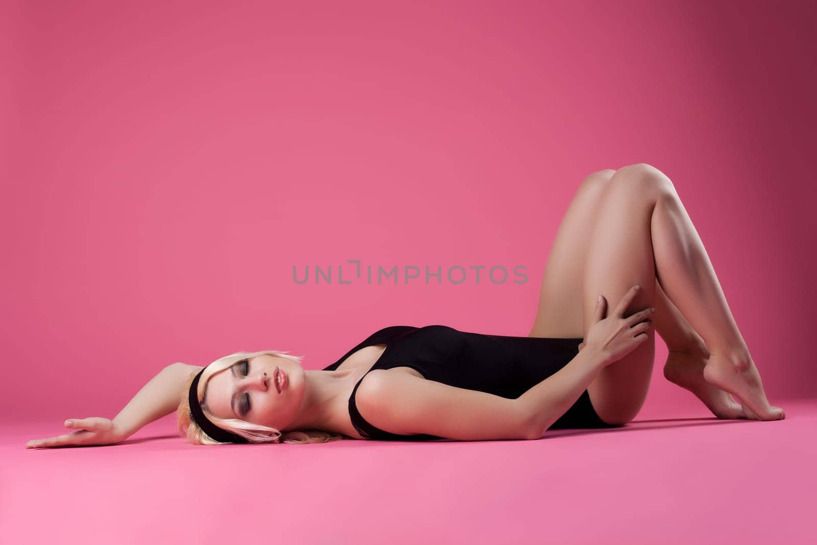Sexy blond woman sport dress relax on pink background