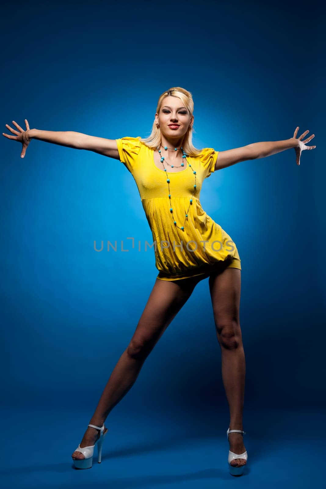 Tall woman in yellow dress pin-up style on blue background