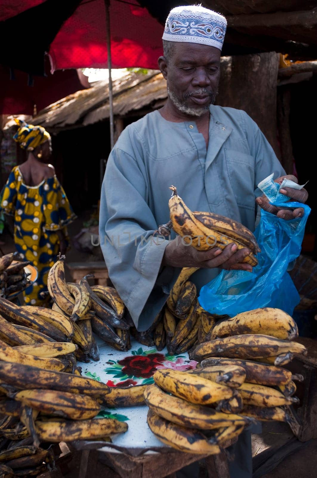 Shopkeeper selling plantain at the local market in Bamako, Mali