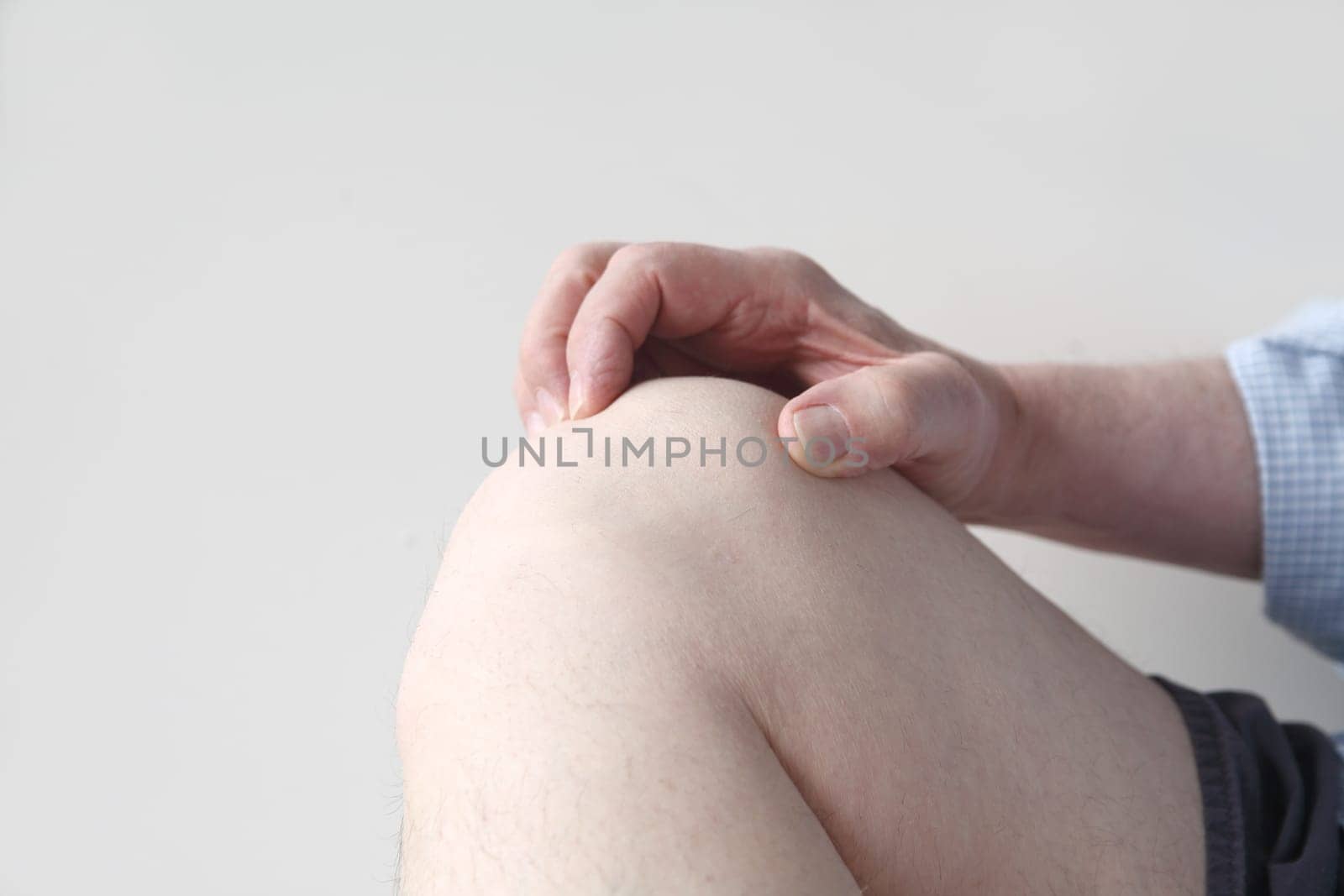 a man holds his aching knee