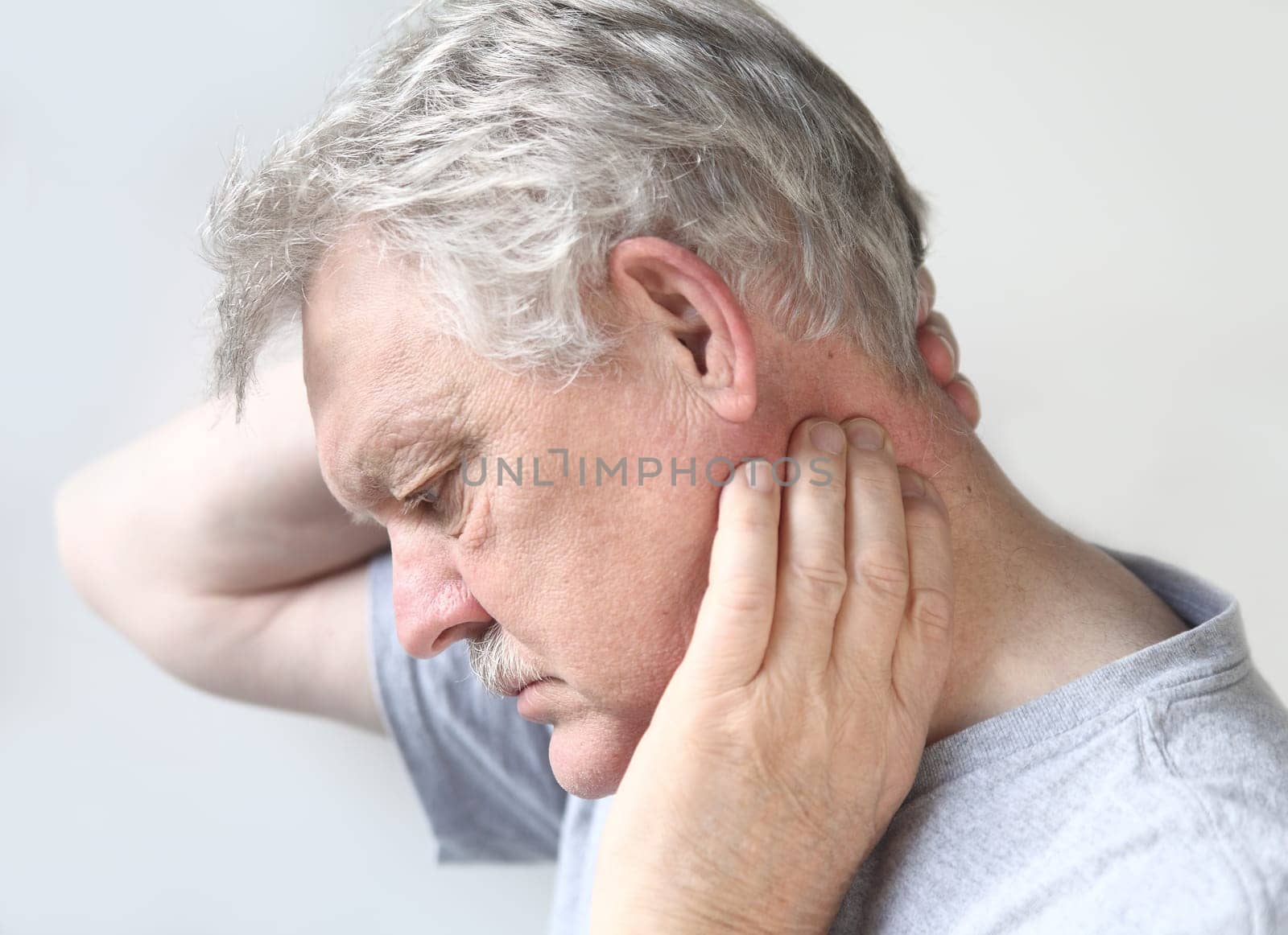 man tries to move his stiff, painful neck
