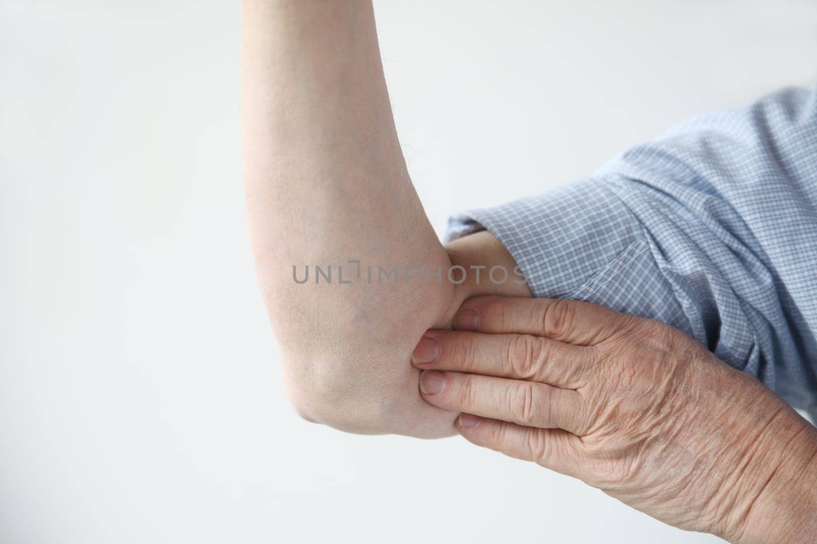 a man indicates where the pain is located in his arm