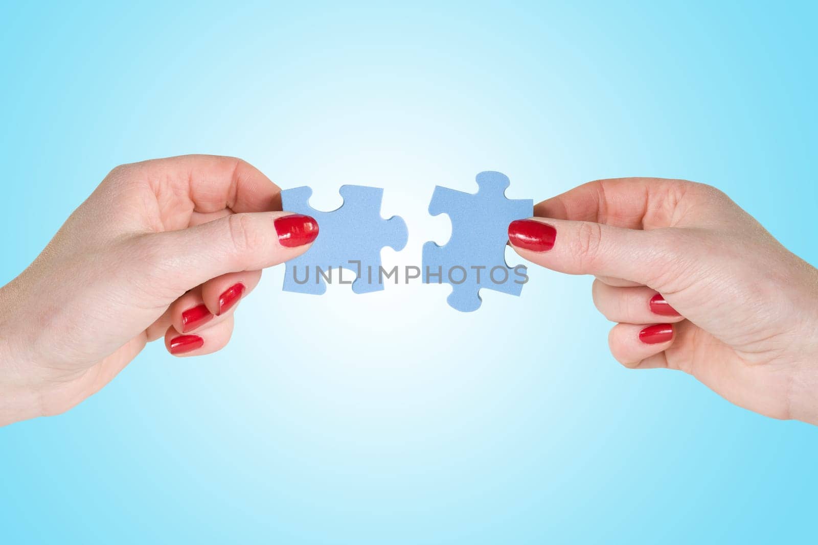 hands  connecting different pieces of blue puzzle