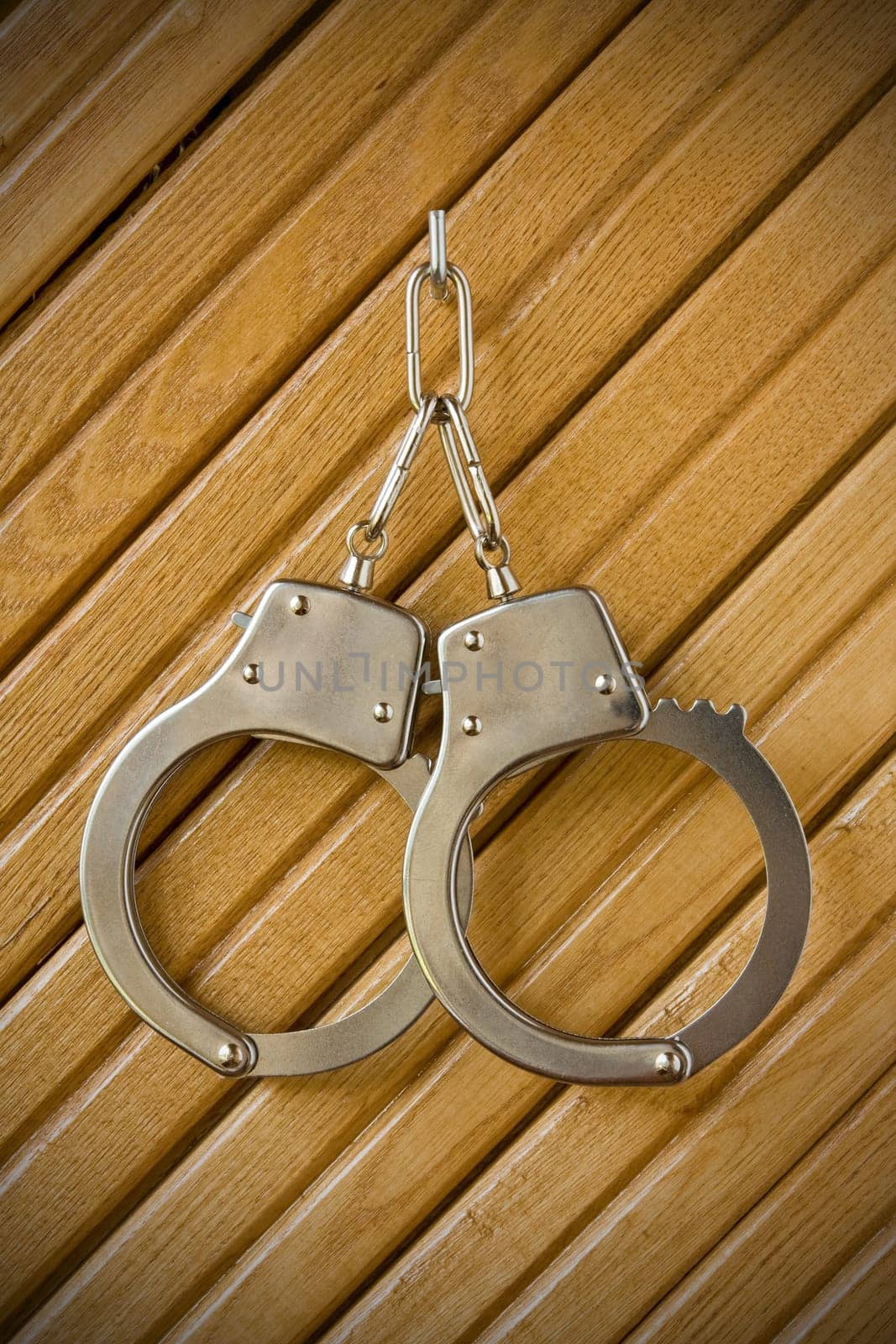 metal handcuffs hanging on the wooden wall