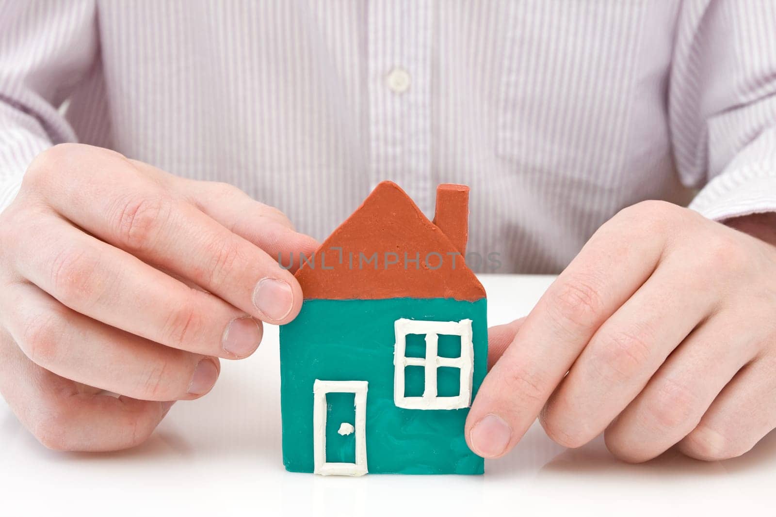 real estate concept. hands making house from plasticine.