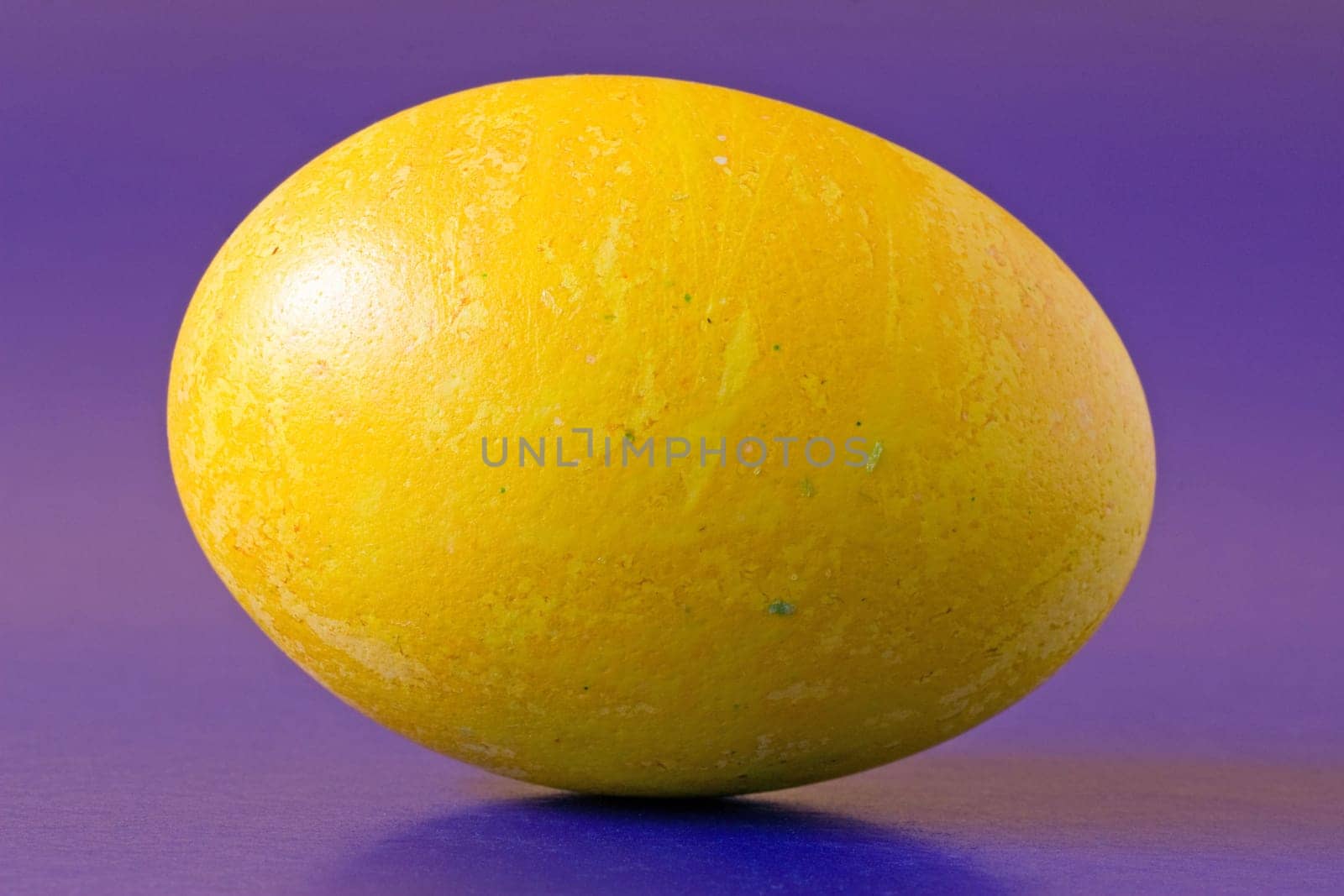 yellow easter egg, isolated on purple background