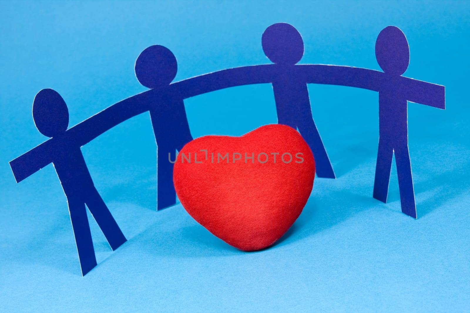 red heart and paper people on blue background