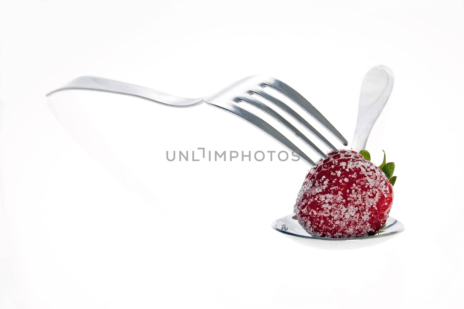 Fresh strawberries dipped in sugar on a spoon