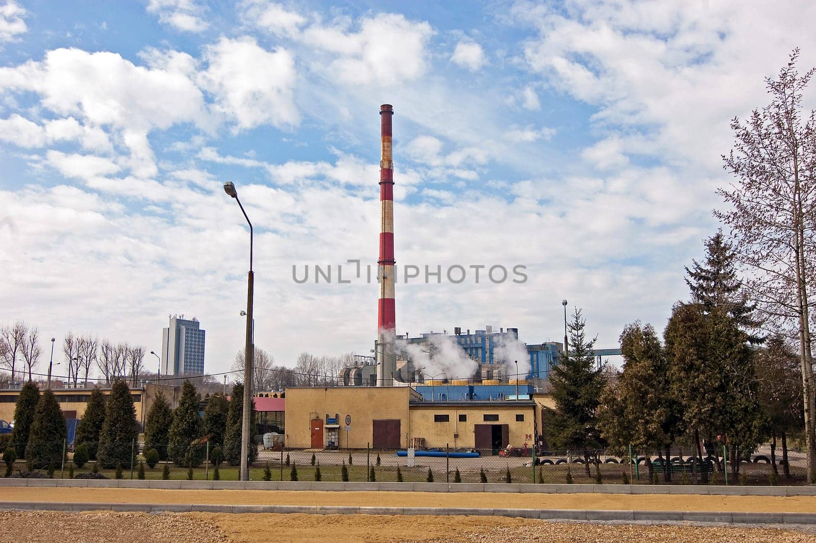 With a smoking chimney power plant on a sunny day