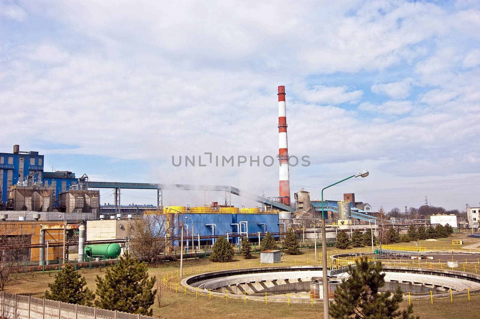 With a smoking chimney power plant on a sunny day