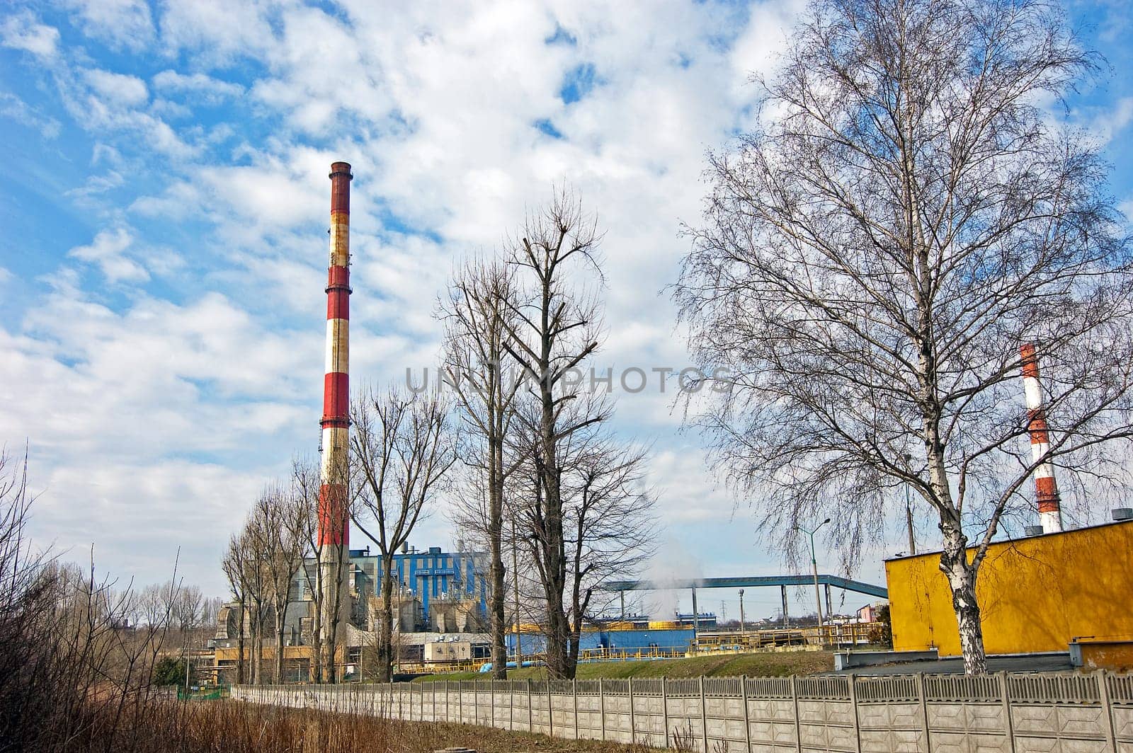 With a smoking chimney power plant on a sunny day