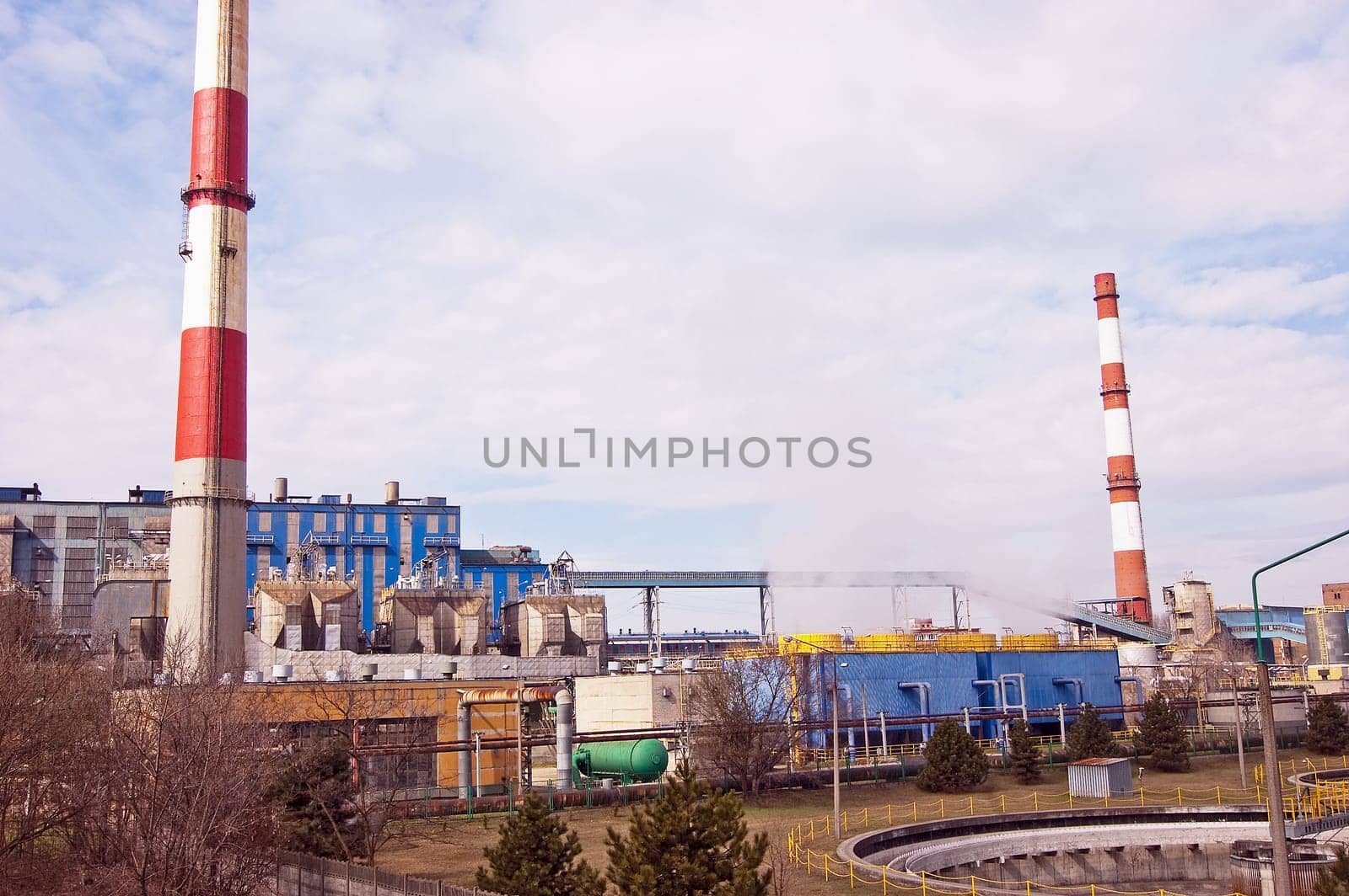 With a smoking chimney power plant on a sunny day