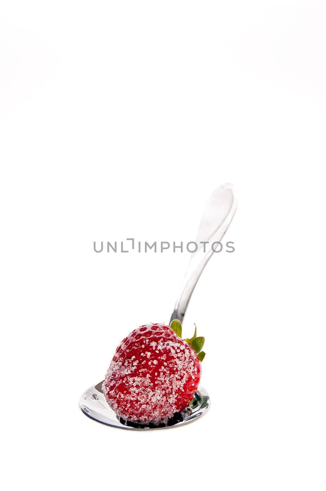 Fresh strawberries dipped in sugar on a spoon