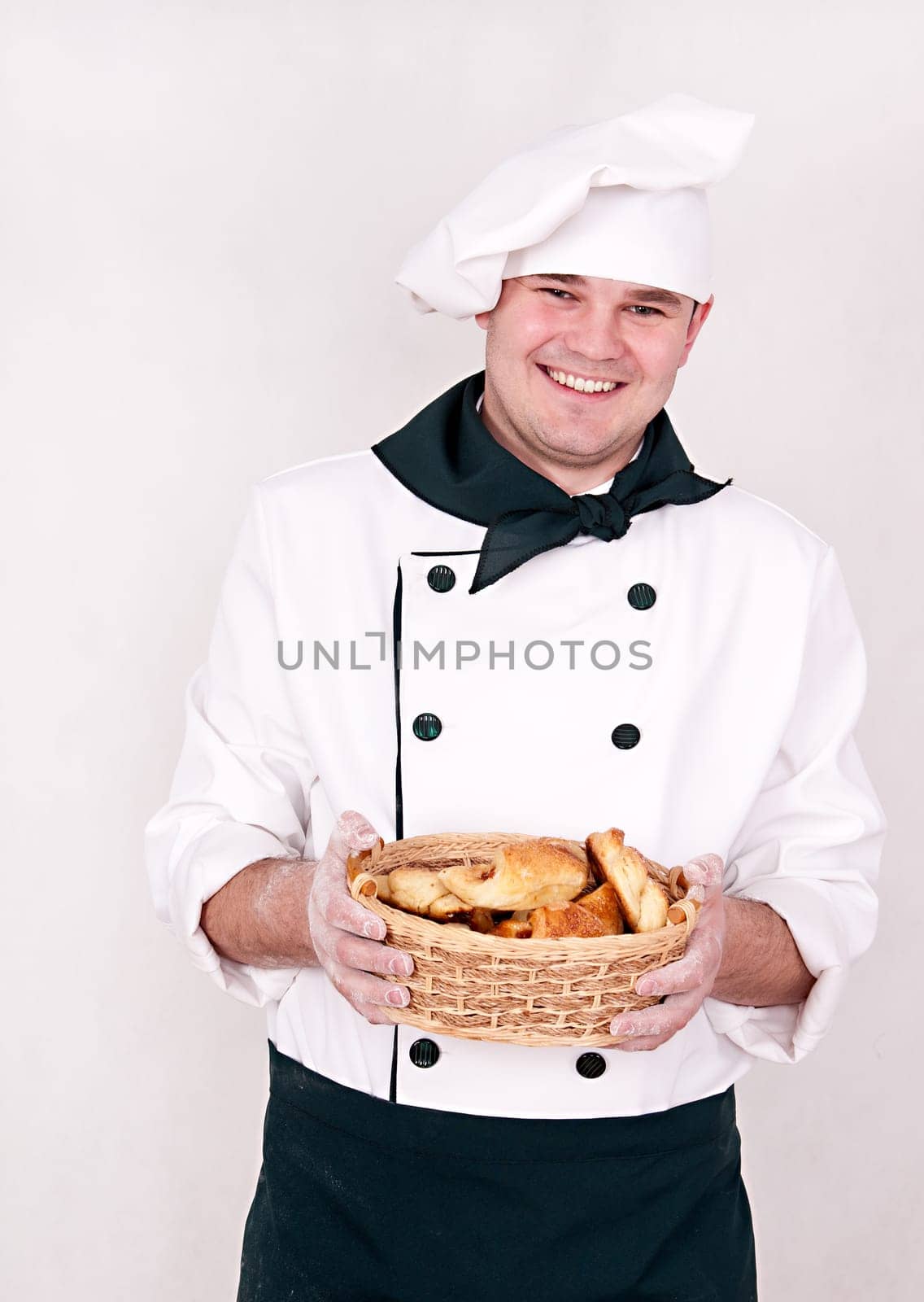 chef keeps basket with buns isolated on white background