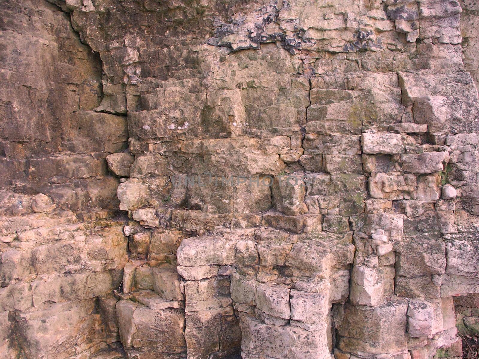 Texture of a hard brown rock wall.