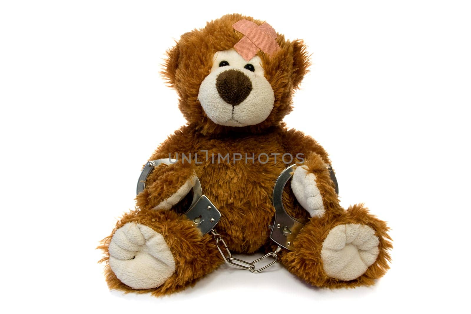 injured and handcuffed Teddy bear on white background