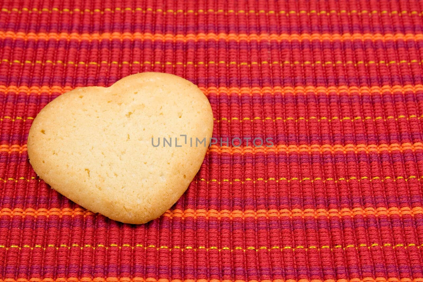 heart shaped cookie on red striped tablecloth