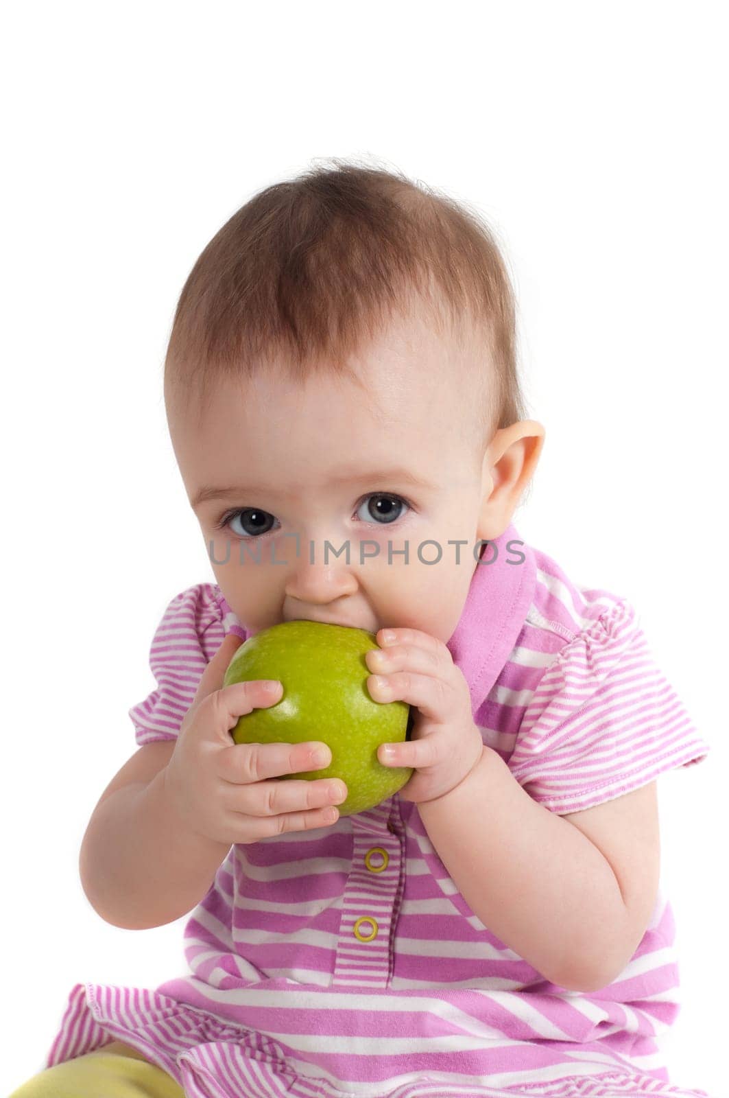 Shot of baby girl on pink eating apple