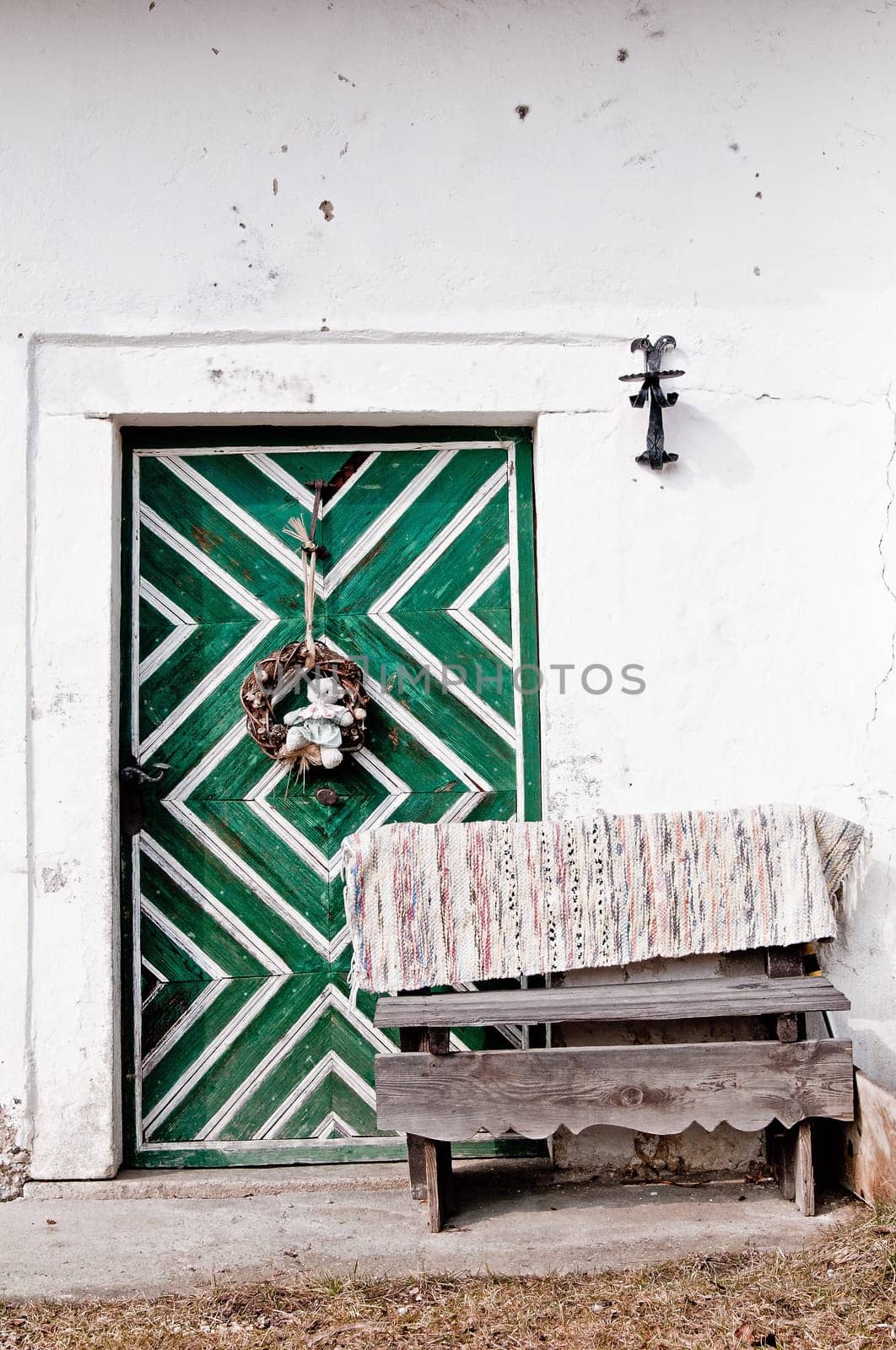 Traditional entry with green door and wooden bench in austria