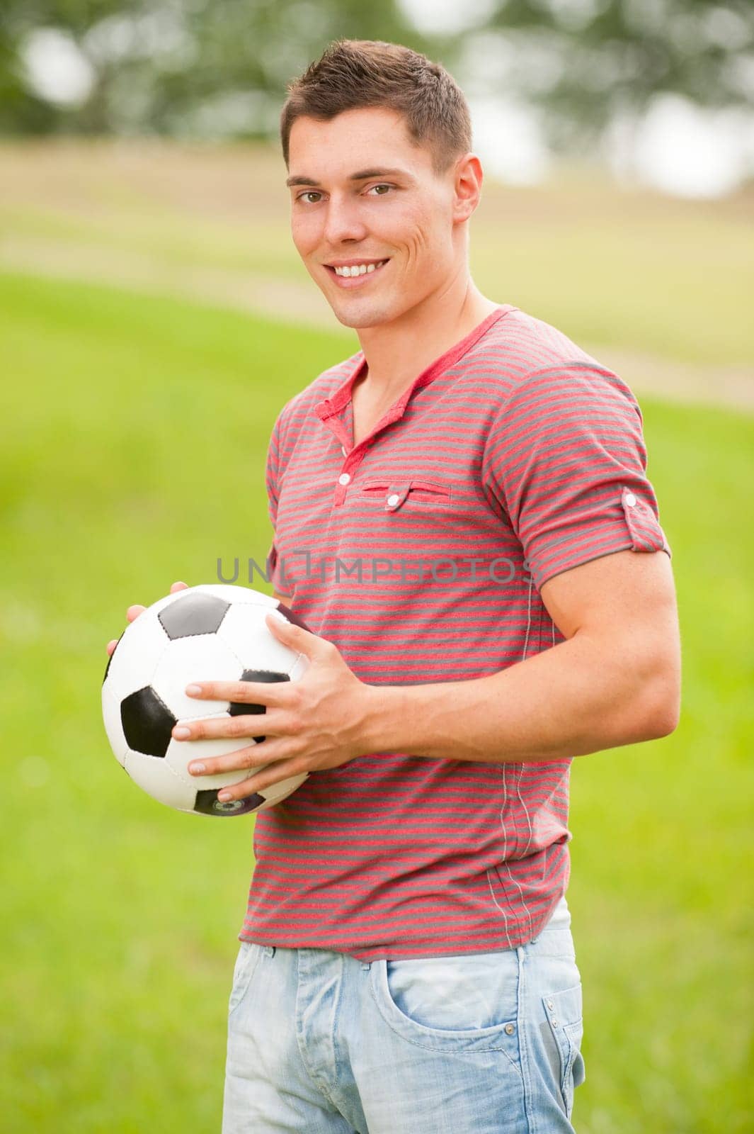 Young man in a park with soccer ball