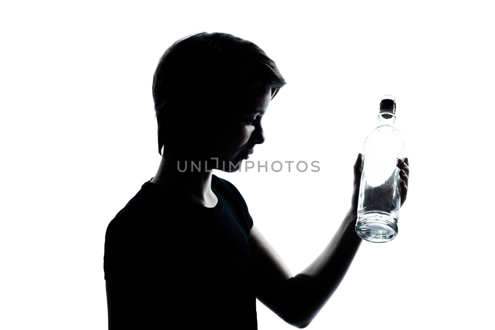 one caucasian young teenager silhouette boy or girl portrait holding empty vodka alcohol bottle in studio cut out isolated on white background