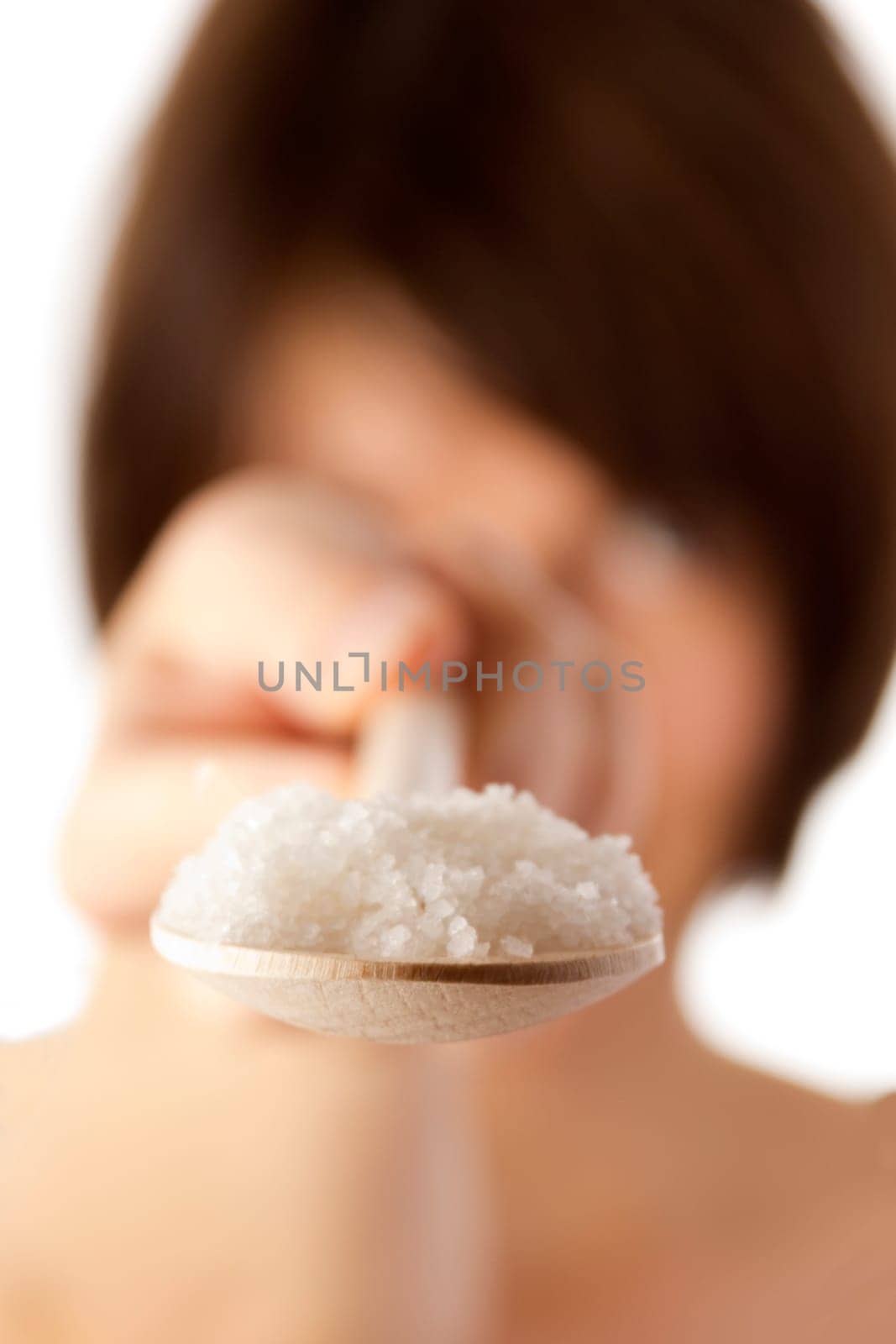 Woman holding spoon with coarse salt