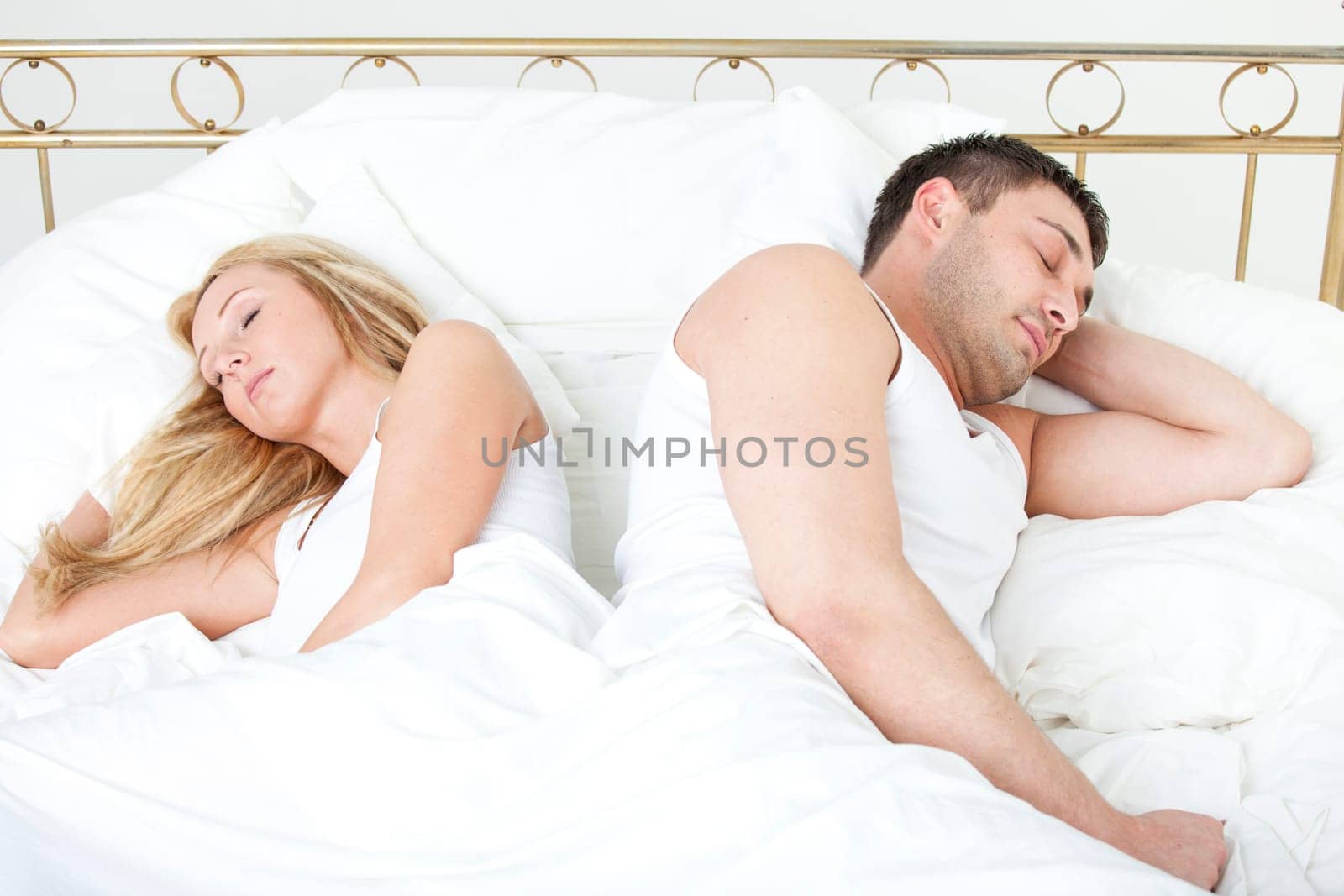 Couple sleeping back on back in bed