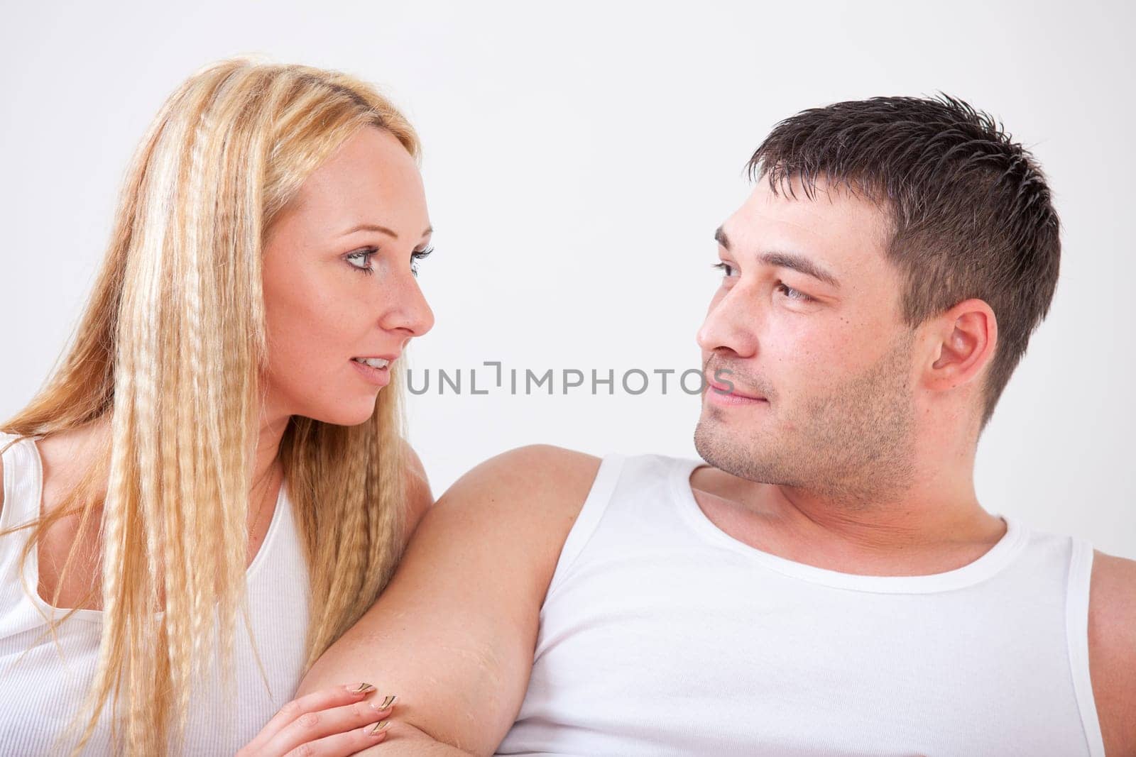 Loving couple in nightwear over white background