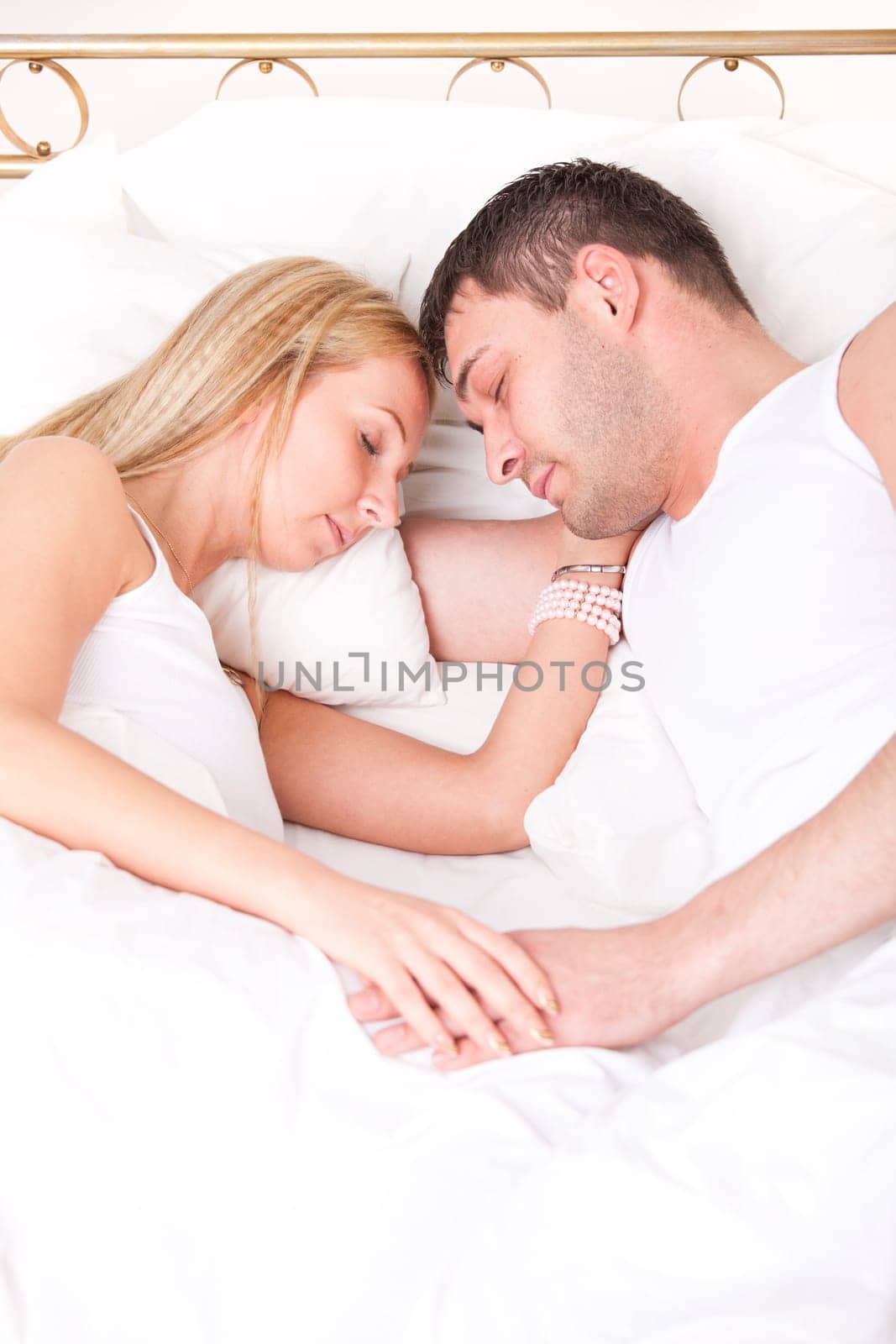 romantic couple in nightwear sleeping in bed