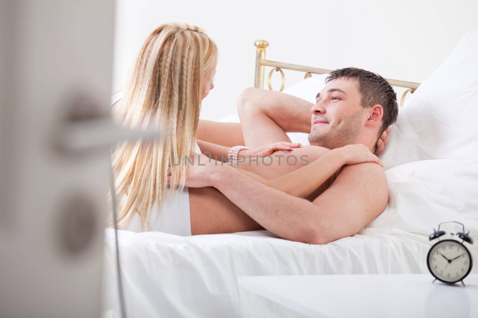 happy young couple cuddling in bed