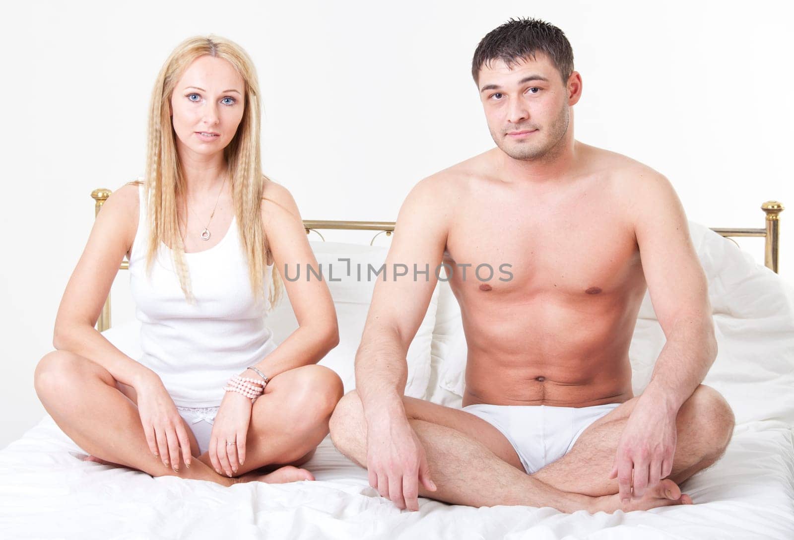 young couple in underwear sitting on the bed