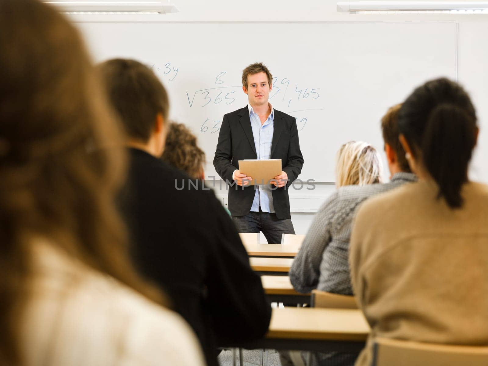 Schoolteacher in front of pupils in the classroom