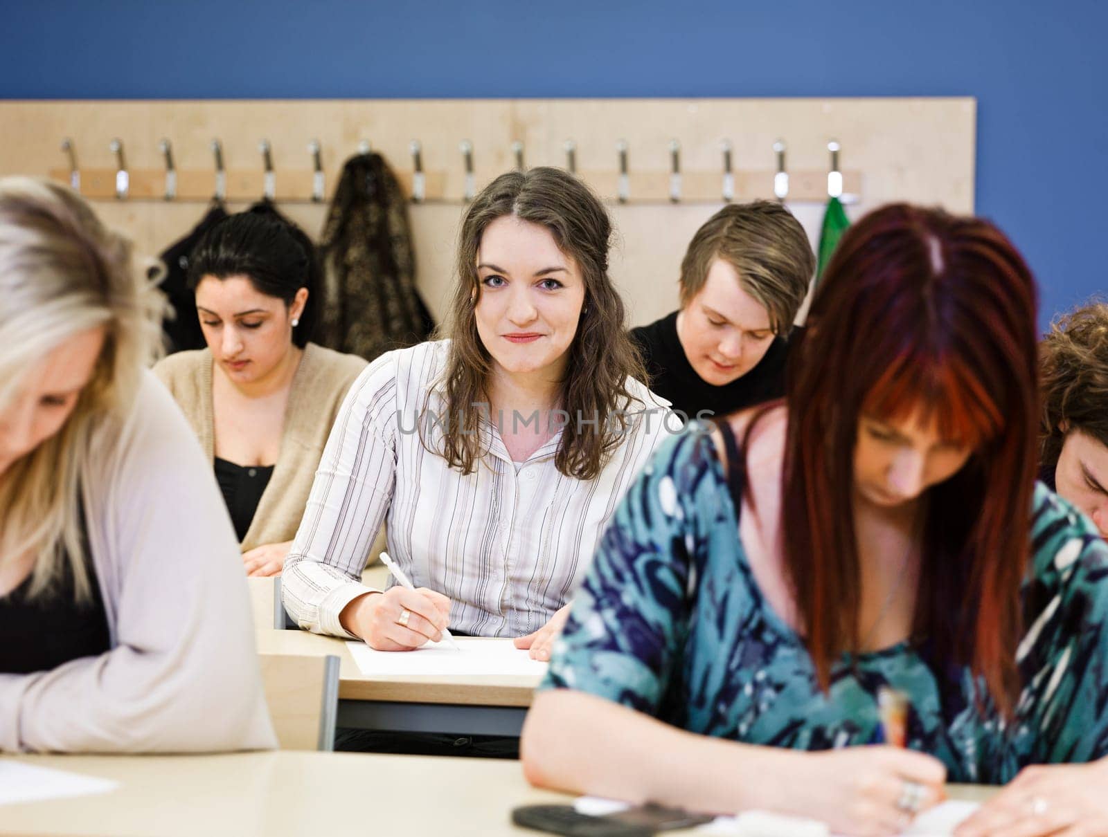Large group of young adults studying in a classroom