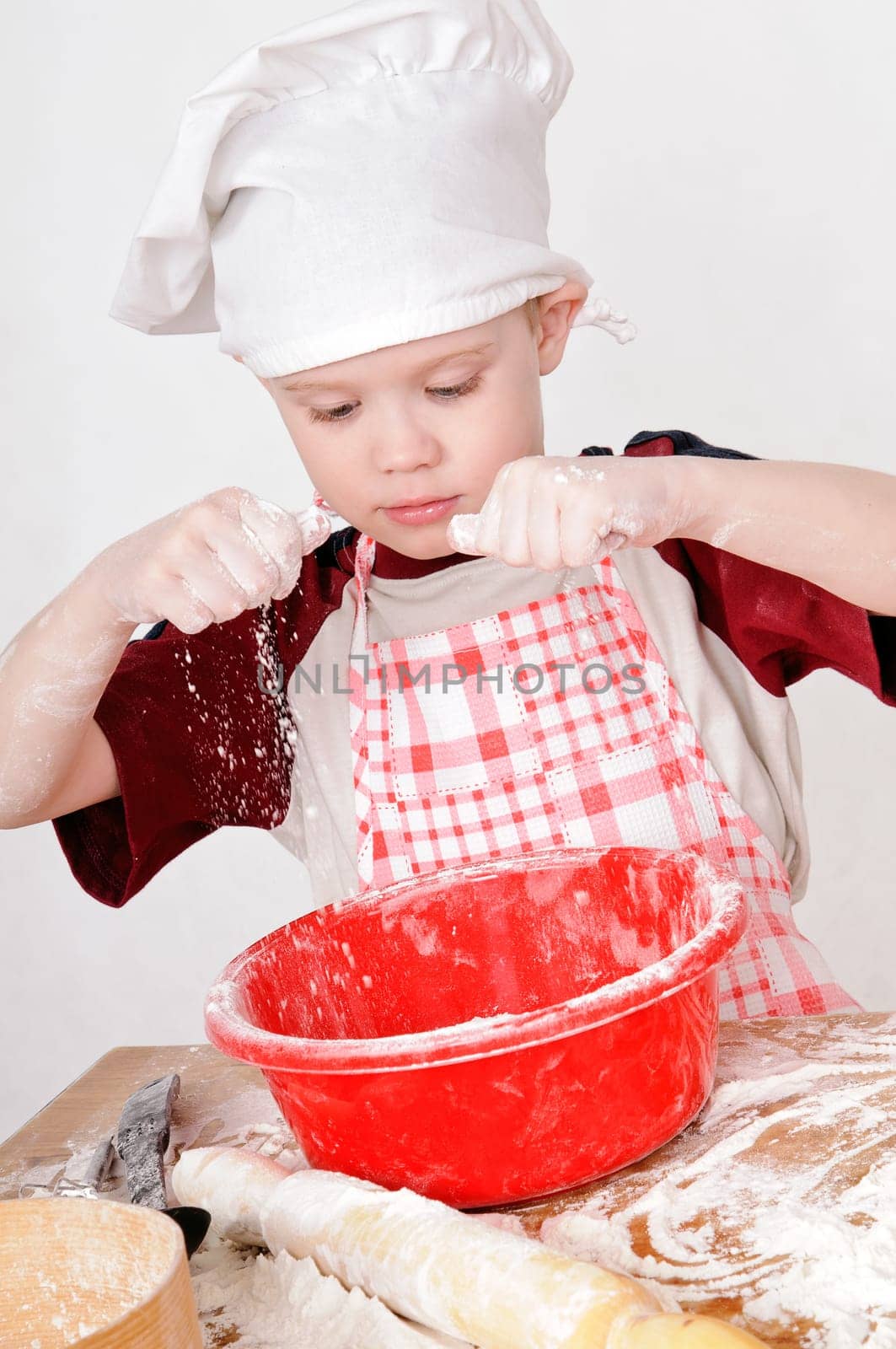 boy in chef hat knead the dough