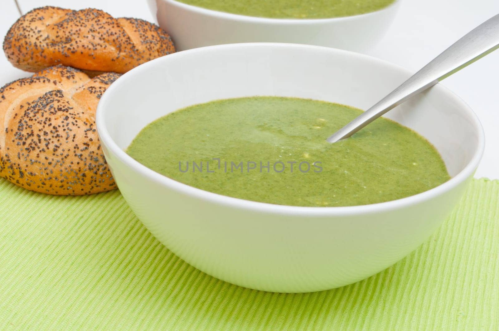 Cream Soup with Spinach in White Bowl and Bread Rolls