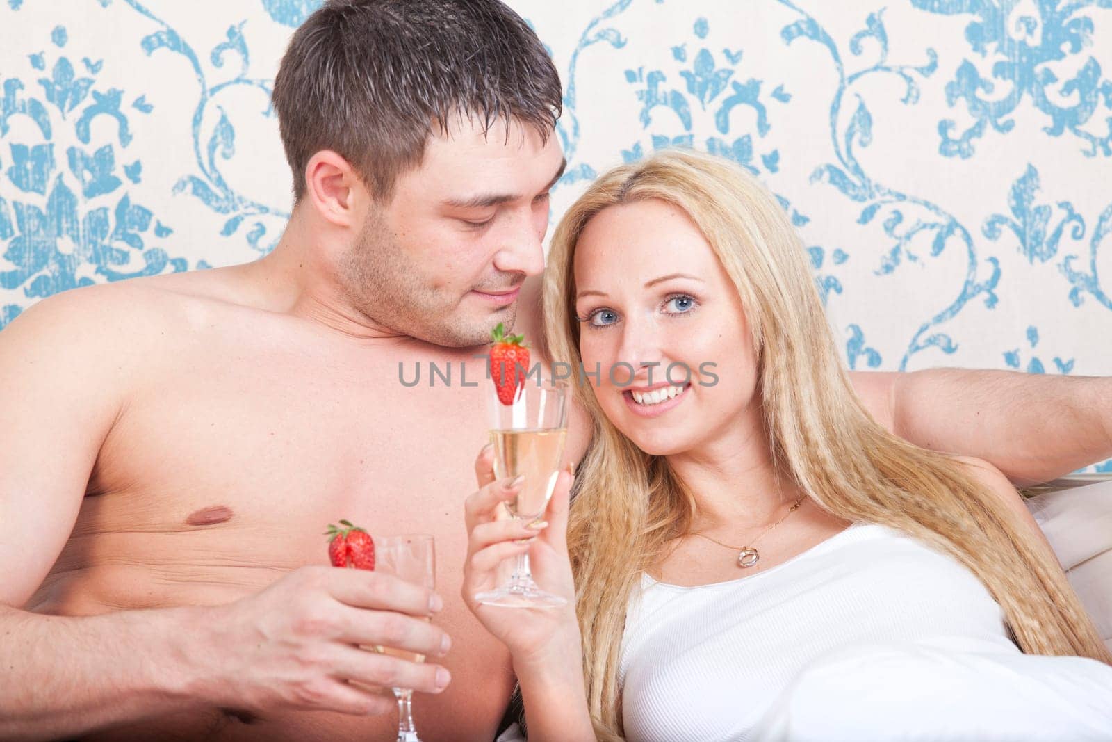 couple in bed with sparkling wine