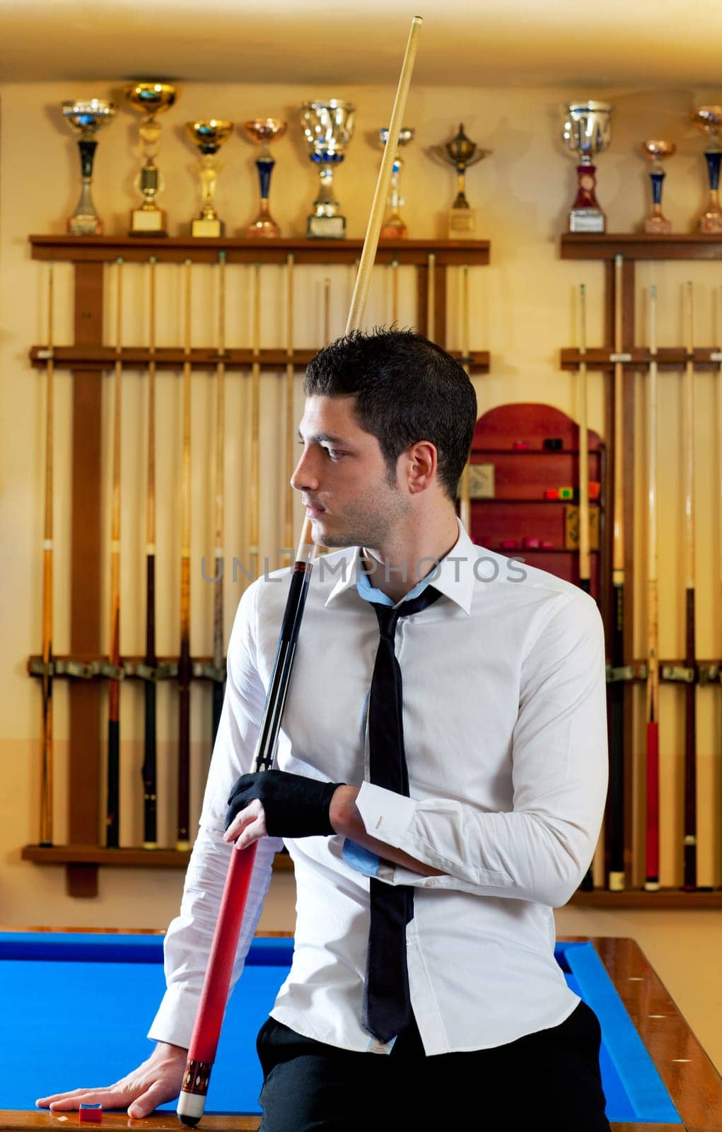 Billiard handsome young winner man with shirt tie and cue at trophy club