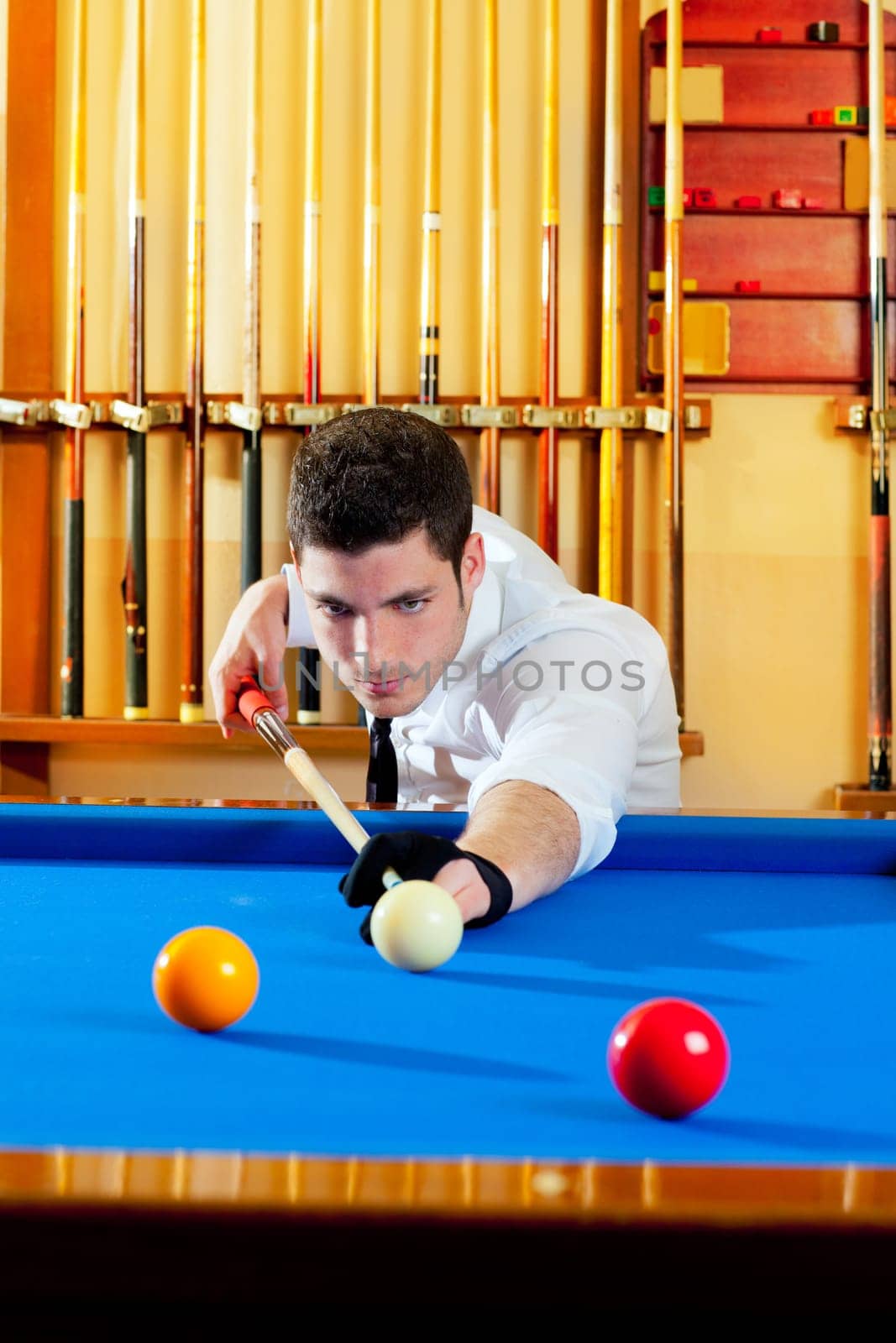 Billiard winner handsome man playing with cue and balls at club