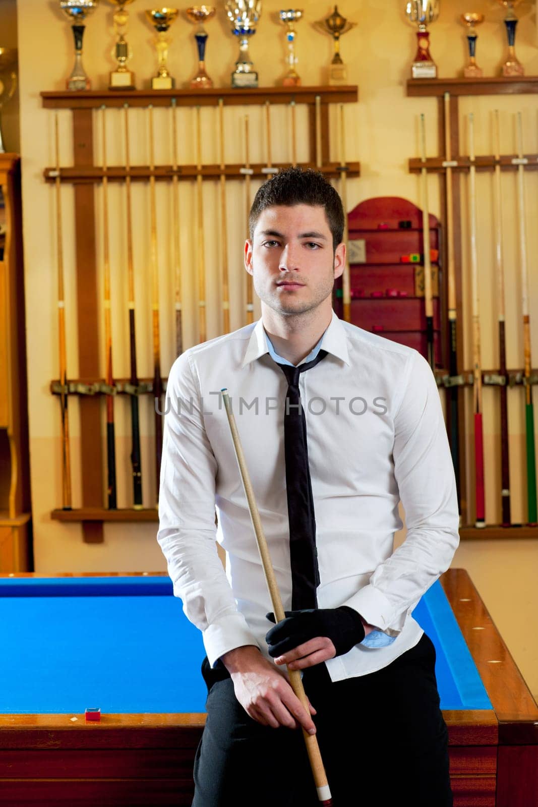 Billiard handsome young winner man with shirt tie and cue at trophy club